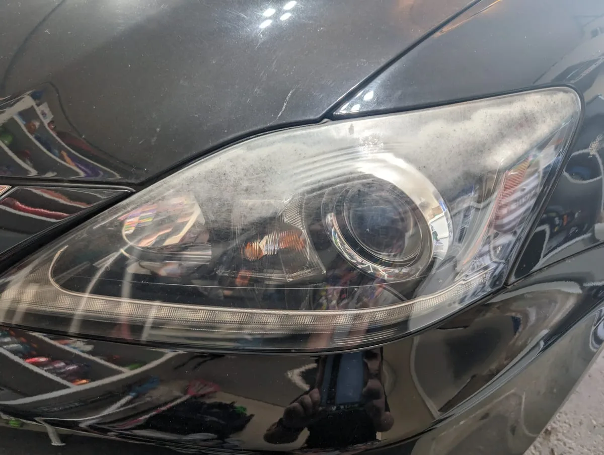 Before headlight restoration — oxidized foggy headlight lens